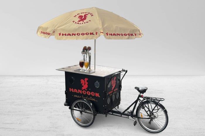 Billedtekst: Mobil udskænkningsladcykel og bar til leje med 2 haner i Kolding og Fredericia Udlejning af mobil ladcykel med 2 haner og parasol til drinks og fadøl i Kolding, Fredericia og Vejle